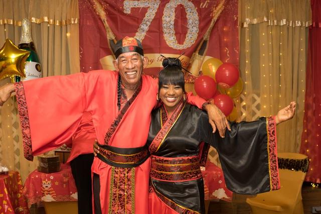 Guests celebrating a 70th birthday in themed attire