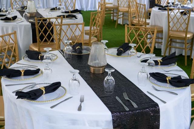 Elegant gold and black table setting for a reception