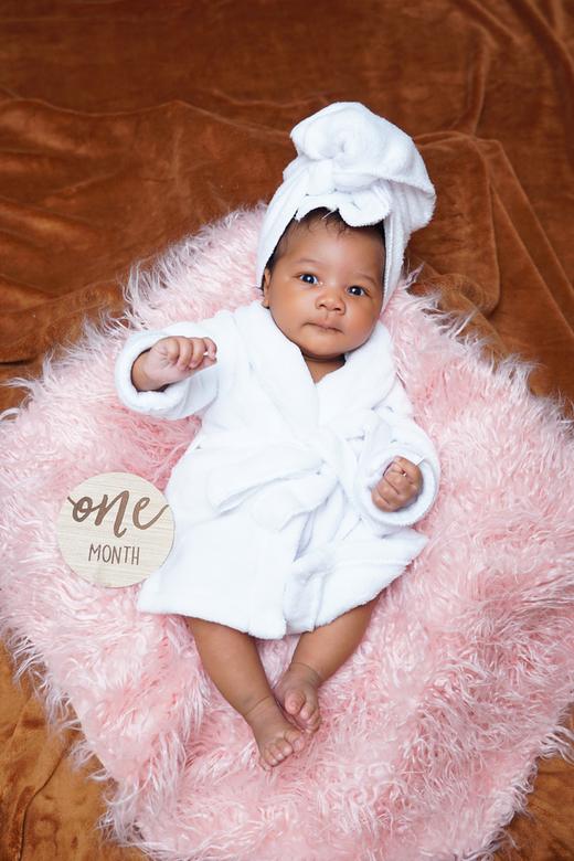 One month old newborn portrait in a white robe